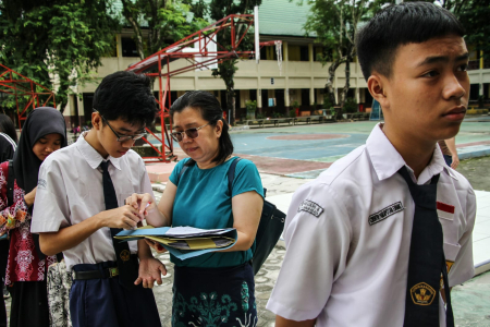 Calon siswa didampingi orang tuanya menyiapkan berkas persyaratan calon peserta didik baru saat daftar ulang di SMA Negeri 2 Palangka Raya, Kalimantan Tengah, Rabu (3/7/2024). ANTARA FOTO/ Aulia Rahman