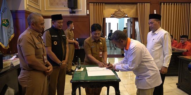 Pj. Wali Kota Malang Wahyu Hidayat (rompi hitam) didampingi Sekda Kota Malang (kiri) dan Plt. Kepala Bakesangpol Kota Malang (tiga dari kiri) menyaksikan penandatanganan BAST. Foto: Pemkot Malang