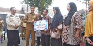 Pj Wali Kota Malang Dr. Ir. Wahyu Hidayat, MM menyerahkan secara simbolis bantuan perbaikan kepada penerima manfaat di Kelurahan Tulusrejo