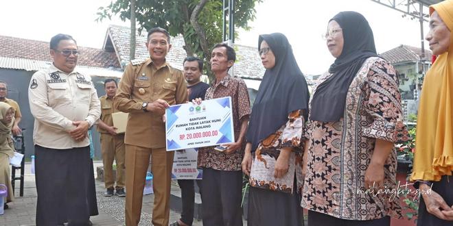 Pj Wali Kota Malang Dr. Ir. Wahyu Hidayat, MM menyerahkan secara simbolis bantuan perbaikan kepada penerima manfaat di Kelurahan Tulusrejo